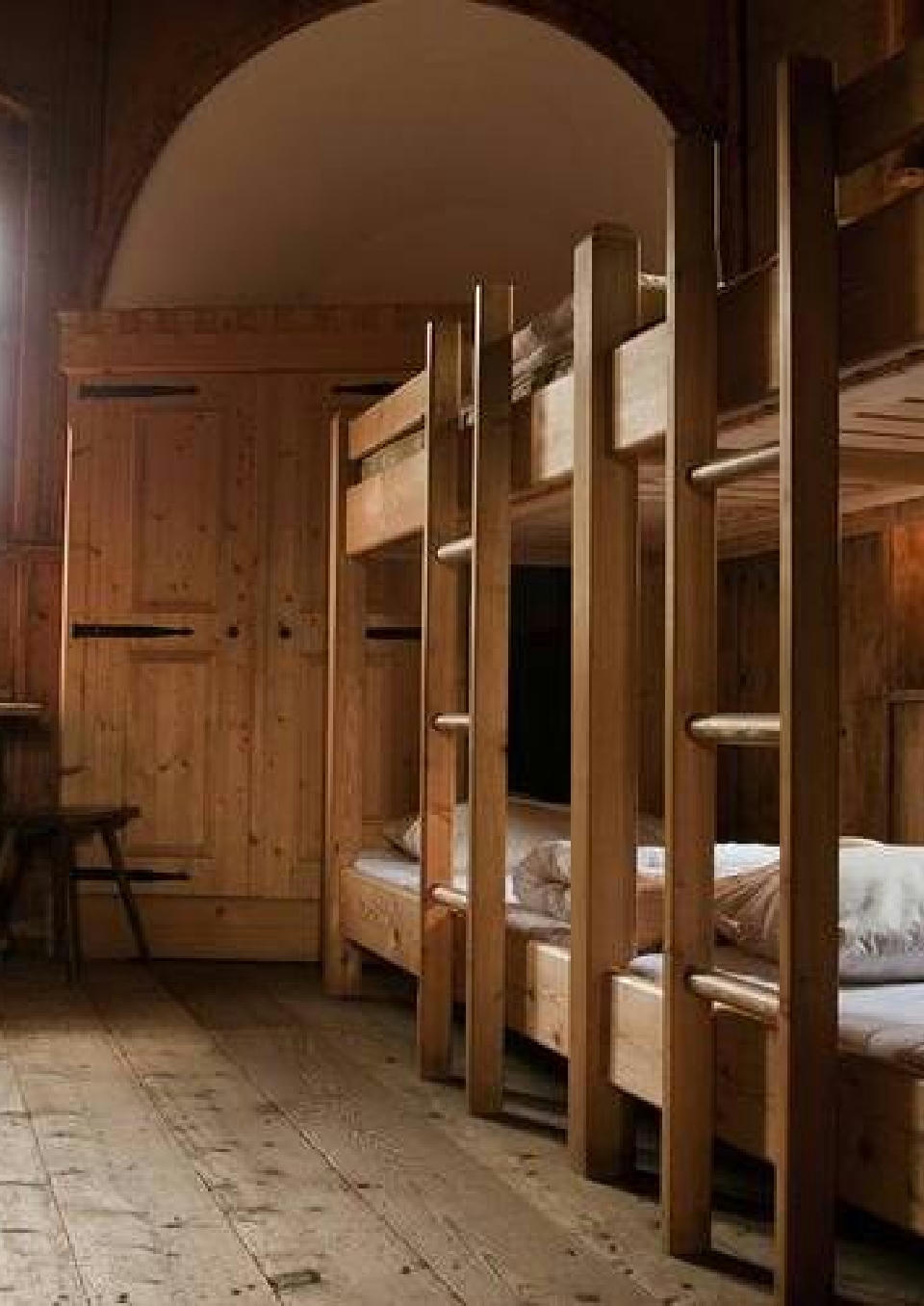 Ein Schlafzimmer für Gruppen auf Burg Finstergrün mit Stockbetten aus Holz.