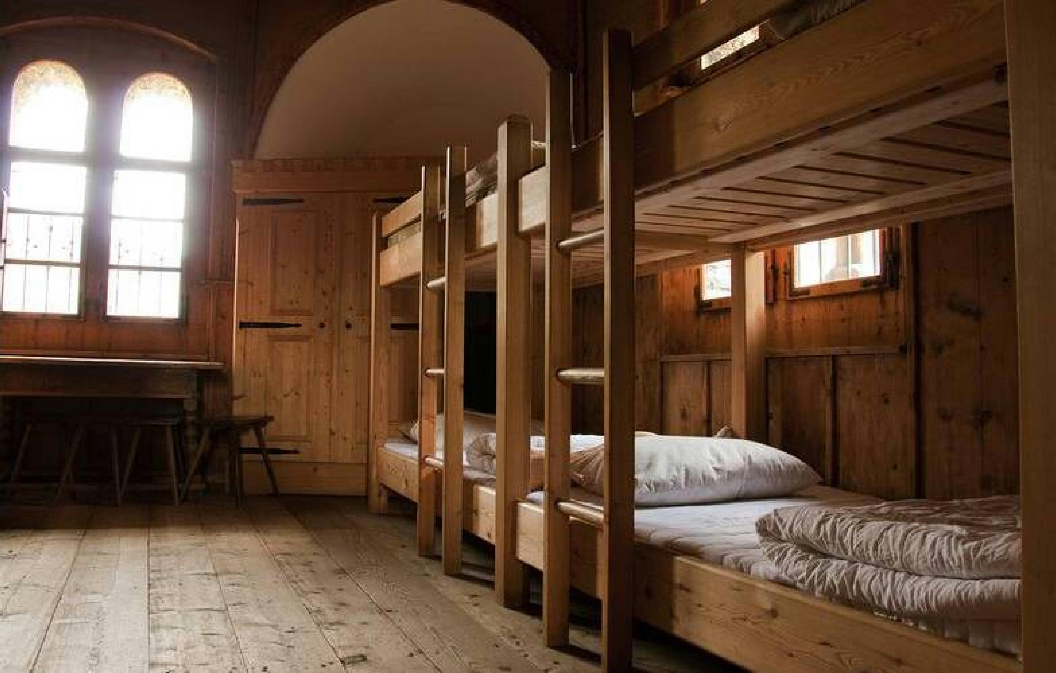Ein Schlafzimmer für Gruppen auf Burg Finstergrün mit Stockbetten aus Holz.